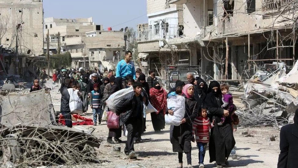 People walking away from destroyed city in Syria during the Syrian Civil War.