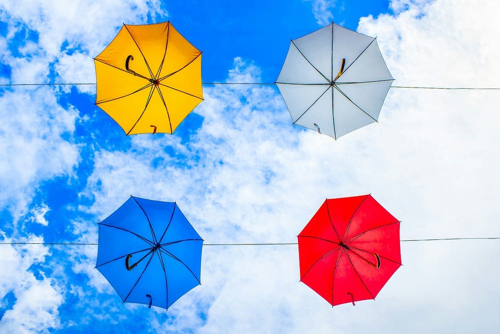 Colourful umbrellas against a blue sky.