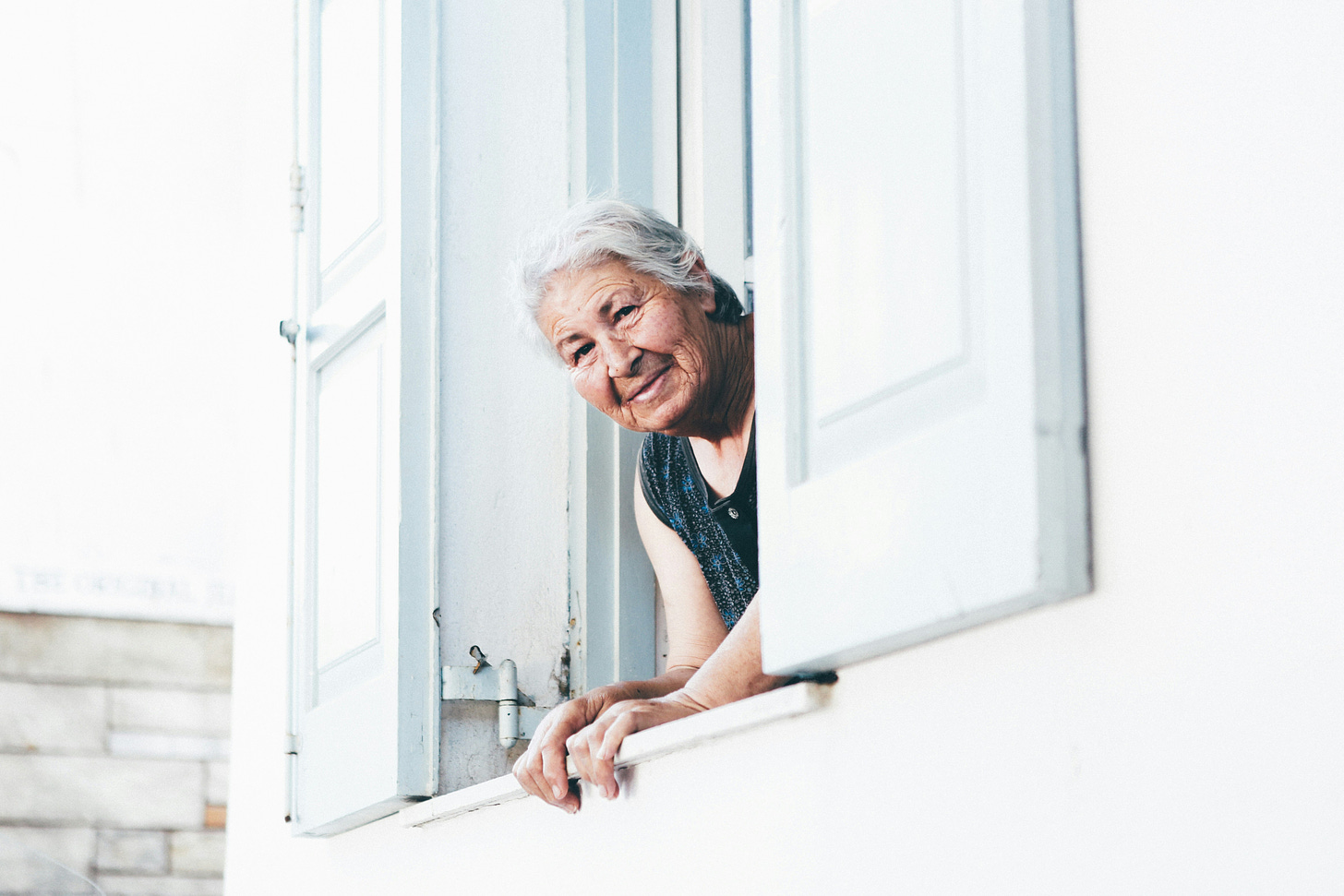 older woman staring out of a window