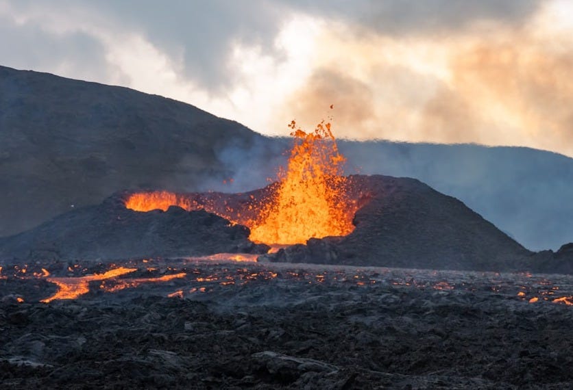 a volcano erupting at sunset