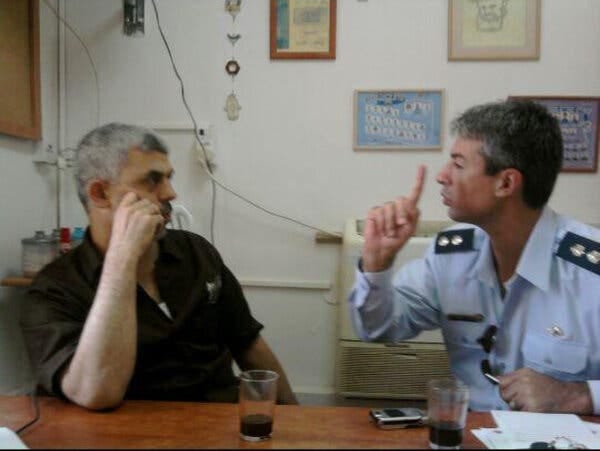 Yahya Sinwar and Dr. Yuval Bitton talking, seated at a table.