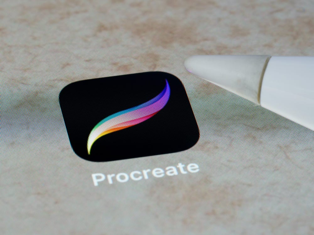 tablet screen with the Procreate logo and an Apple pencil about to touch it. 