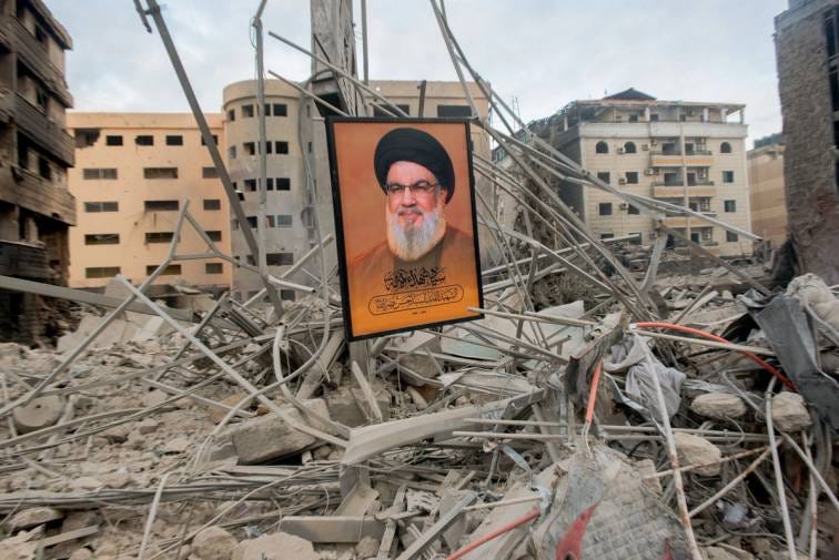 Um pôster de Sayyed Hassan Nasrallah está entre os escombros de edifícios destruídos por ataques aéreos israelenses em Beirute, em 11 de outubro de 2024