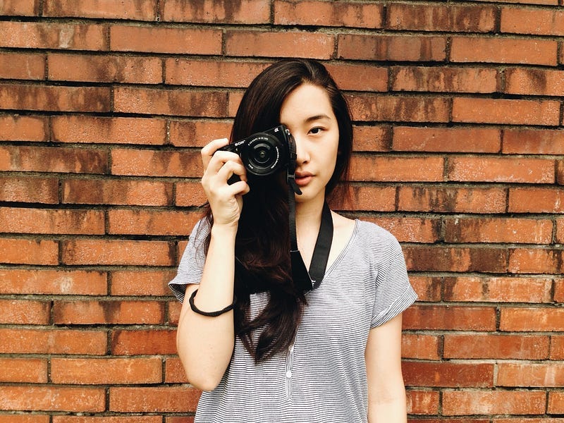 Long-haired Asian girl holding a camera