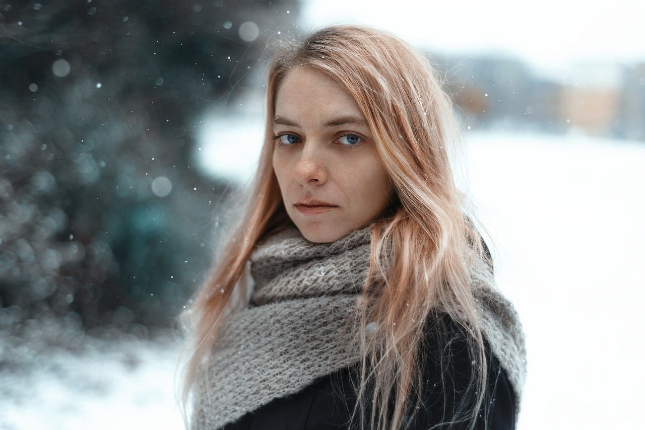 young woman in snow feeling sad symptoms