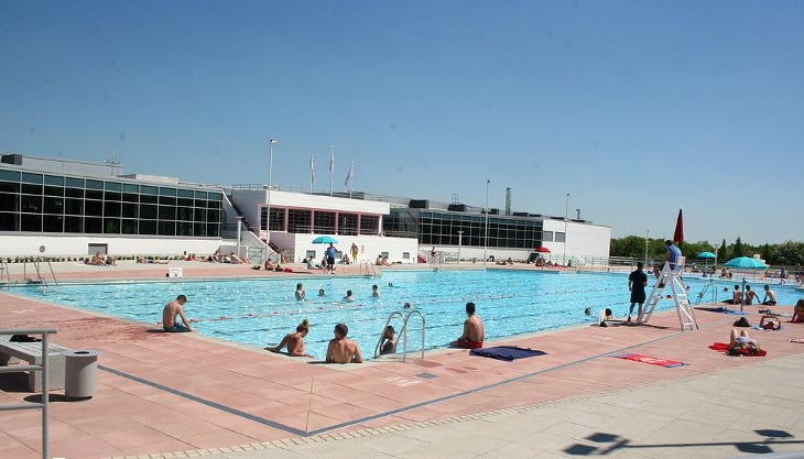 People in an outdoor pool People in an outdoor pool