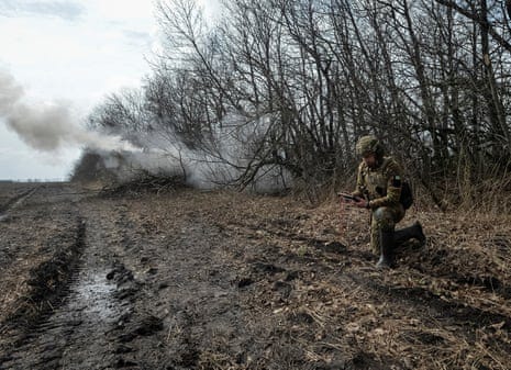 Ukrainian servicemen fire a self-propelled howitzer towards Russian troops.