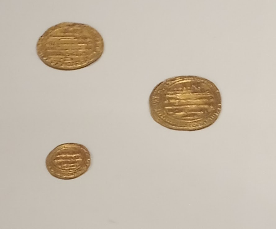 Three gold coins, perfect circles, with detailed text embossed