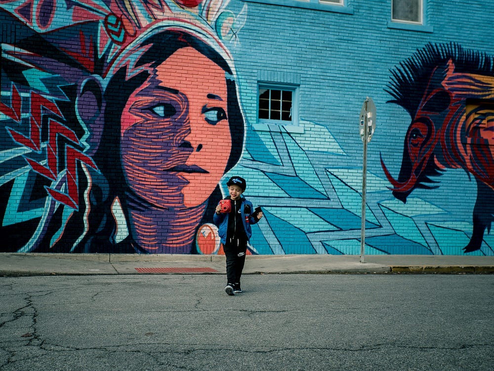 Colourful wall art with a woman face and the image of a wild boar.