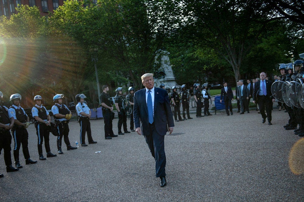 Trump is protected by police in riot gear shortly before his Bible stunt in front of St John's Episcopal Church