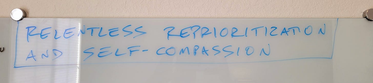 picture of a whiteboard that says "relentless reprioritization and self-compassion"​