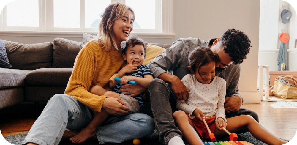 Mom, Dad and two kids playing together in the living room