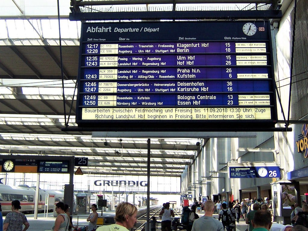 Image of a departure board at Munich station. From left to right, it shows: departure time, route identifier, key stations, the destination, the platform number, and additional service information.