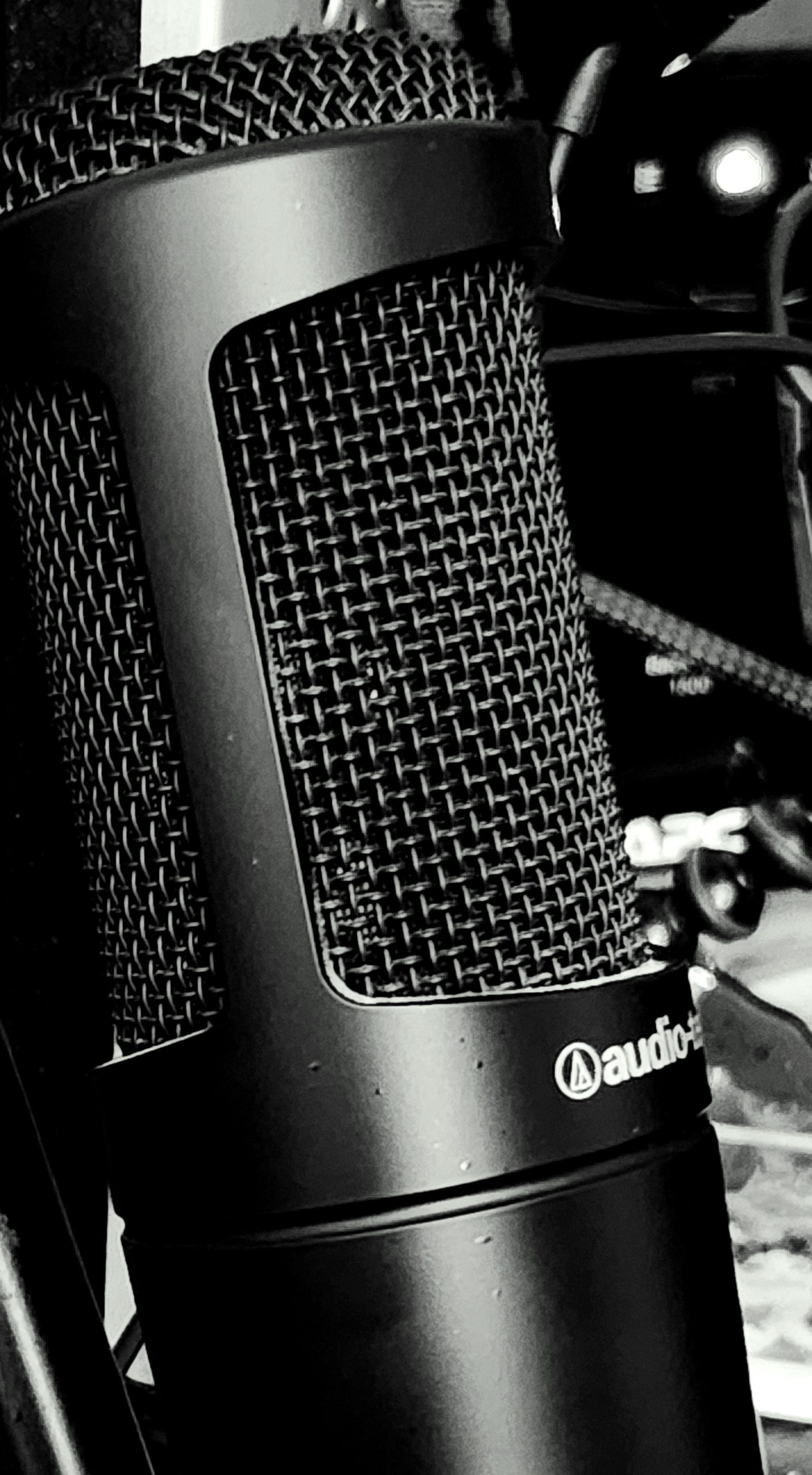 Black and white photograph of an AT2035 large diaphragm condenser microphone in situ.