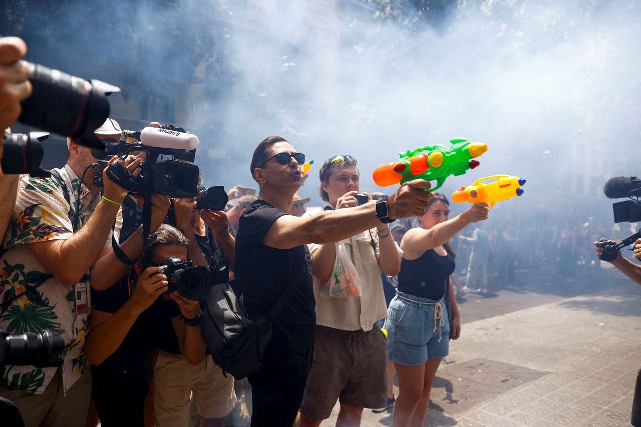 Demonstrators use water pistols to protest mass tourism in Barcelona. (Bruna Casas/Reuters)