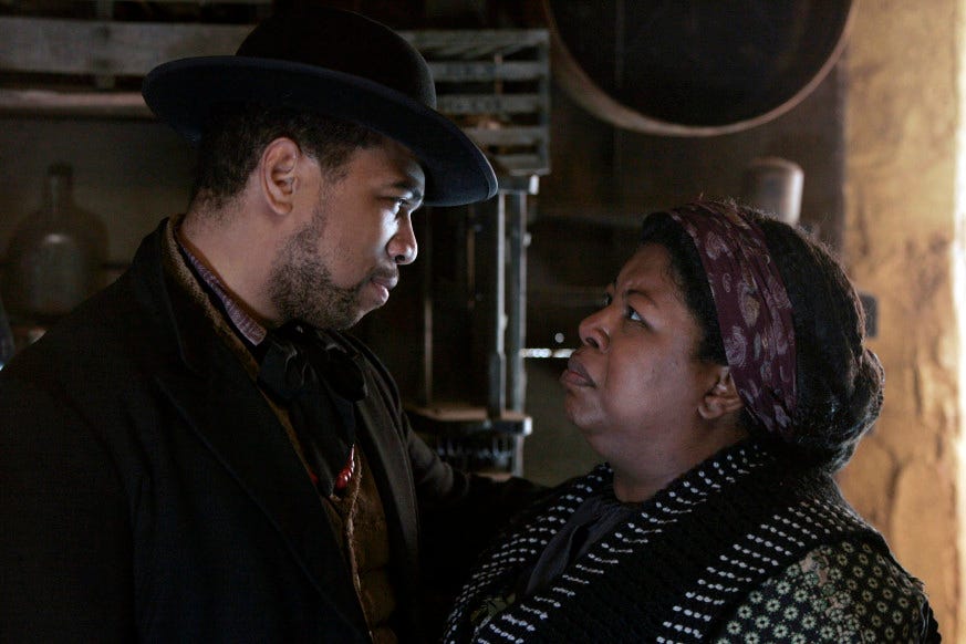 This image shows Odell Marchbanks (played by Omar Gooding) on the left and his mother, "Aunt" Lou Marchbanks (played by Cleo King) on the right. Mother and son stare directly into one another's eyes, with Lou appearing upset at something Odell has just told her.