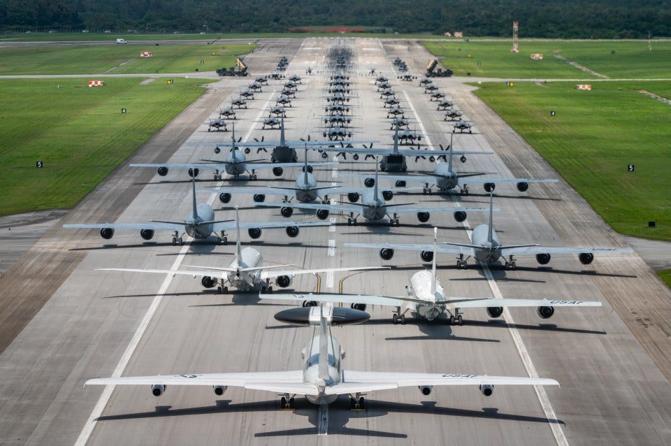 Aerial view of military aircraft lined up on a runway for an elephant walk exercise.