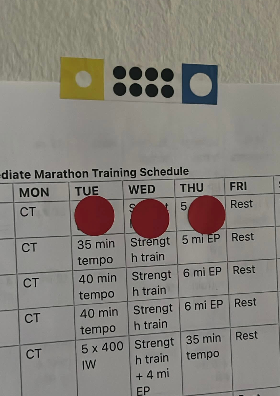 Marathon training schedule with three days marked off with red dot stickers.
