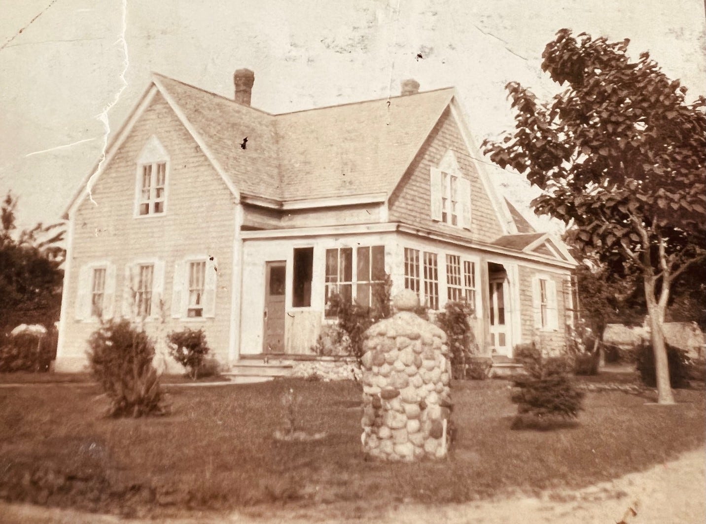 A house with a stone pillar in front of it

Description automatically generated