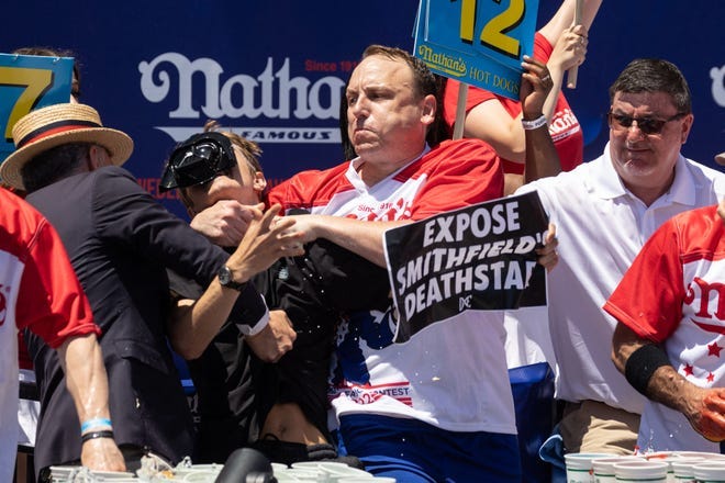 Joey Chestnut tackles a protester who interrupted the Nathan's Hot Dog Eating Contest.