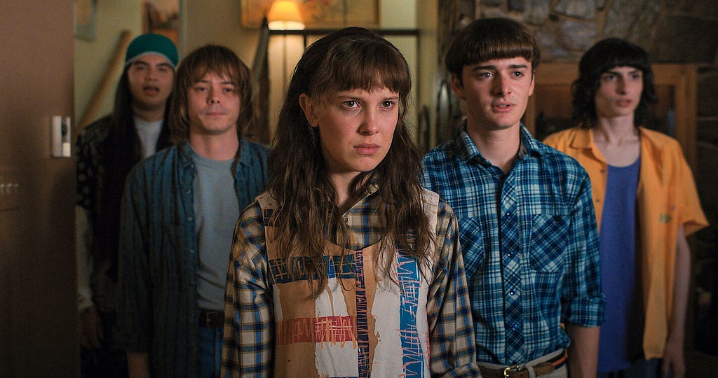 Eleven from Stranger Things stands defiant with her friends from Hawkins.