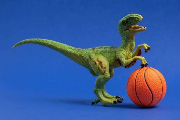 Green dinosaur toy with basketball ball