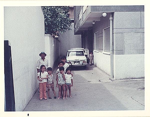 The watchman and neighborhood children, Ky Dong apartment, Saigon, 1974.

Description automatically generated