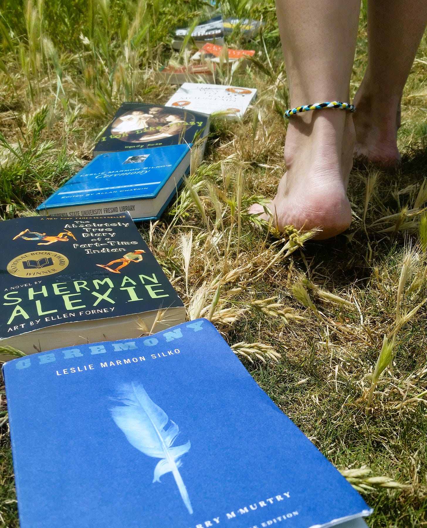Feet of a young person walking along a path of books in grass