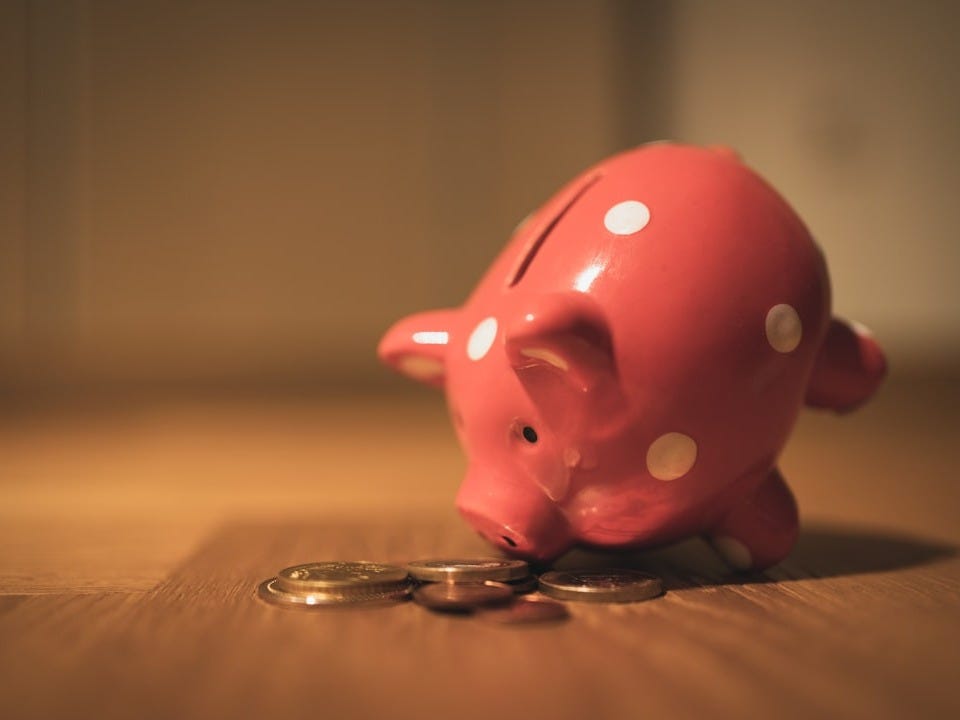 pink pig coin bank on brown wooden table