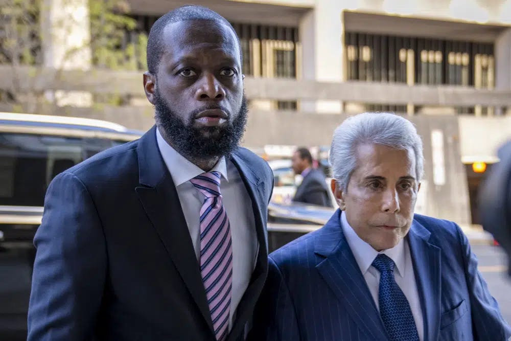 FILE - Prakazrel "Pras" Michel, left, a member of the 1990s hip-hop group the Fugees, accompanied by defense lawyer David Kenner, right, arrives at federal court for his trial in an alleged campaign finance conspiracy, Thursday, March 30, 2023, in Washington. Michel, who was accused in multimillion-dollar political conspiracies spanning two presidencies, was convicted Wednesday, April 26, after a trial that included testimony ranging from actor Leonardo DiCaprio to former U.S. Attorney General Jeff Sessions. (AP Photo/Andrew Harnik, File)