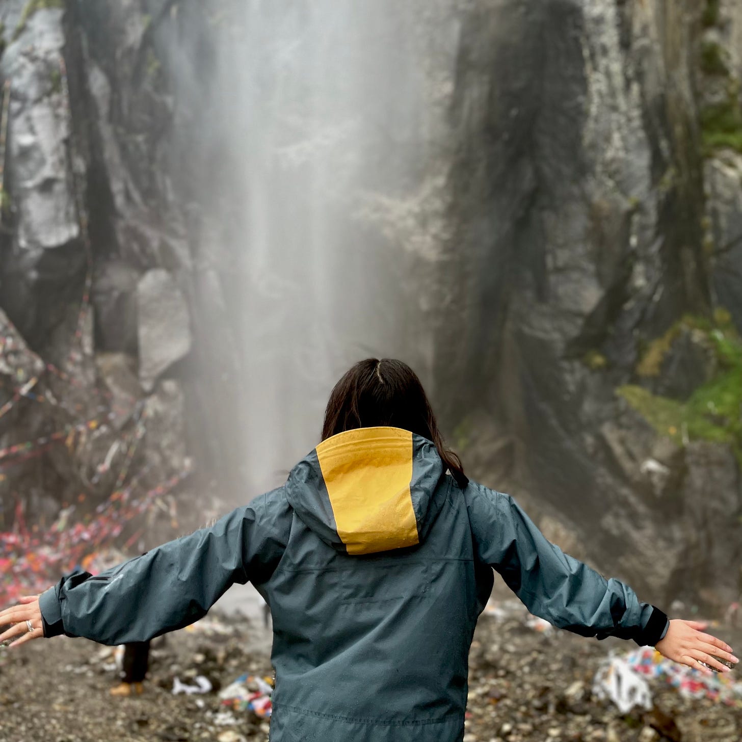 Woman surrendering to flow of waterfall