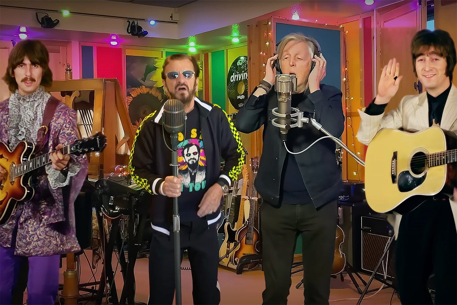 George, Ringo, Paul, and John of the Beatles stand in a performance space, Ringo and Paul as their present-day selves, George and John from archival footage.