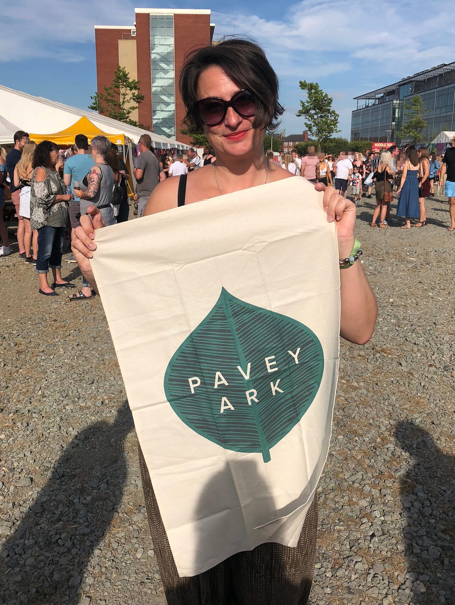 Sarah Farley standing outside at Humber Street Festival holding a Pavey Ark tea towel from the Leaf by Leaf EP