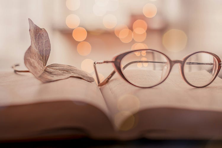 Spectacles placed on an open book.