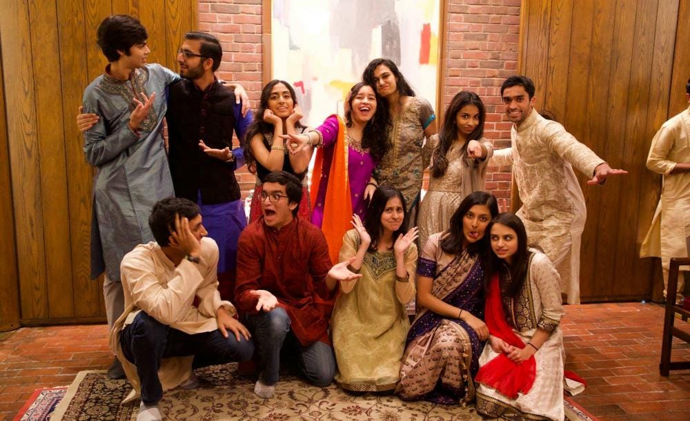 Group of students wearing Indian clothes indoors posing and smiling