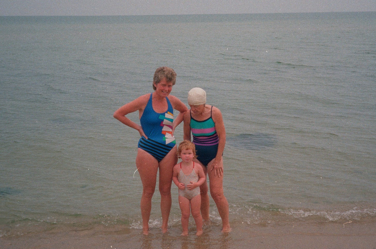 My grandmother, my mother and me, age 3, standing at the edge of the ocean on a cloudy day.