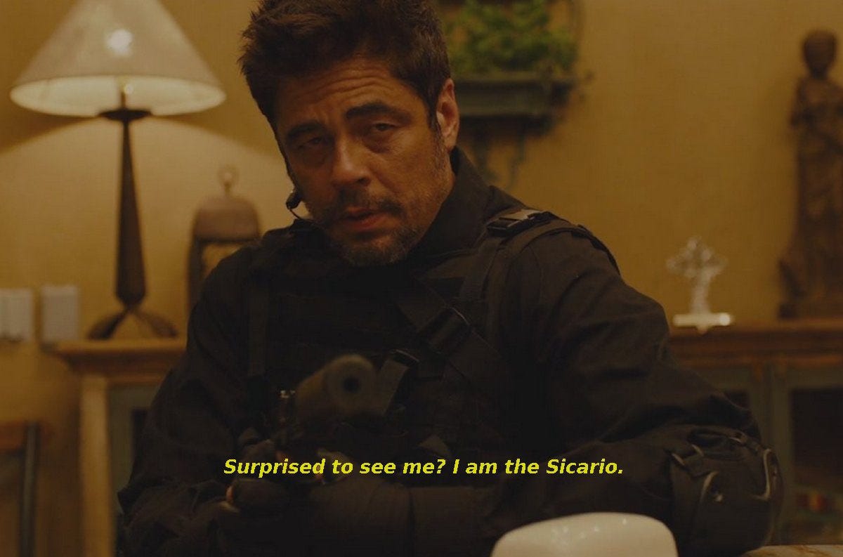 A scene from a movie. Benicio Del Toro’s Alejandro is geared up, point a gun. He makes the big reveal, saying, “Surprised to see me? I am the Sicario.”