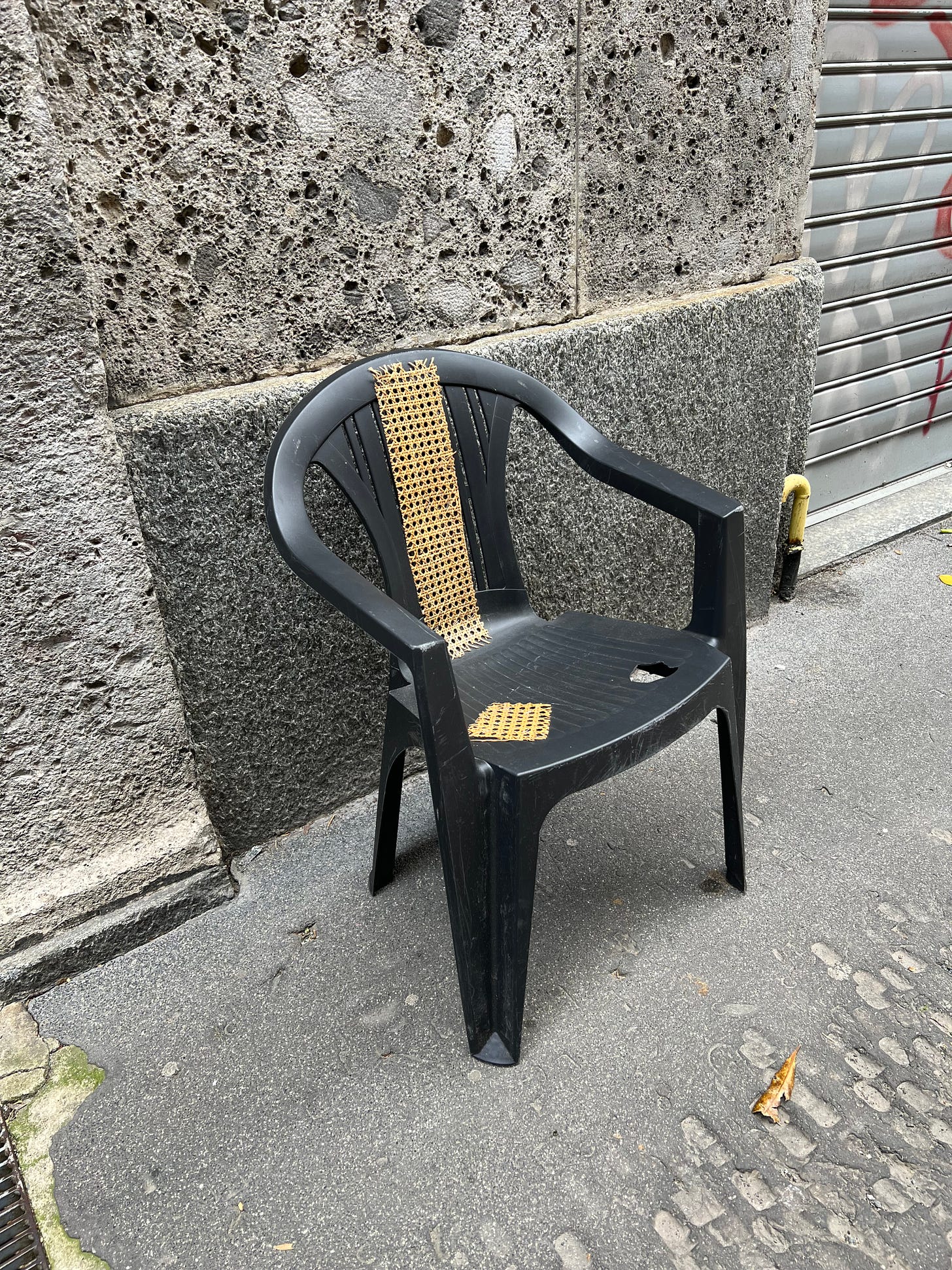 Black Monobloc on the street. Some holes on the seat are roughly fixed with Viennese wickerwood.