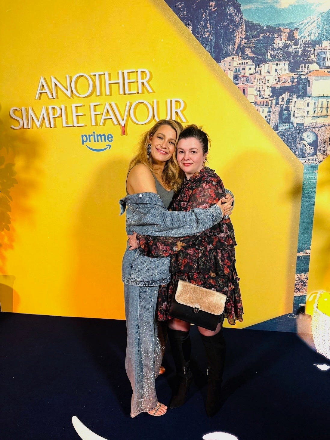 Amber and Blake Lively hug each other and smile at the camera on the carpet of the London screening of "Another Simple Favor."