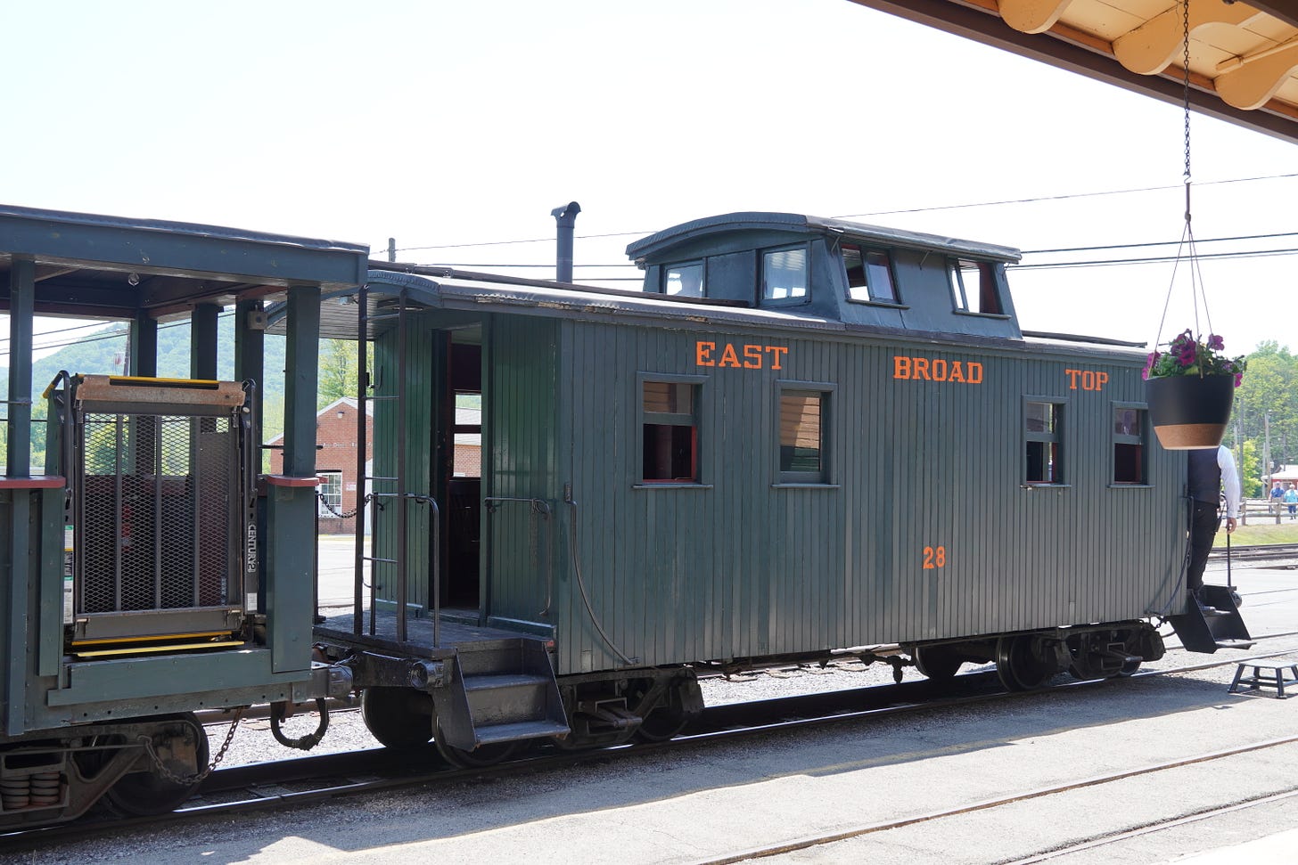 A wooden green caboose with the words East Broad Top on the side.