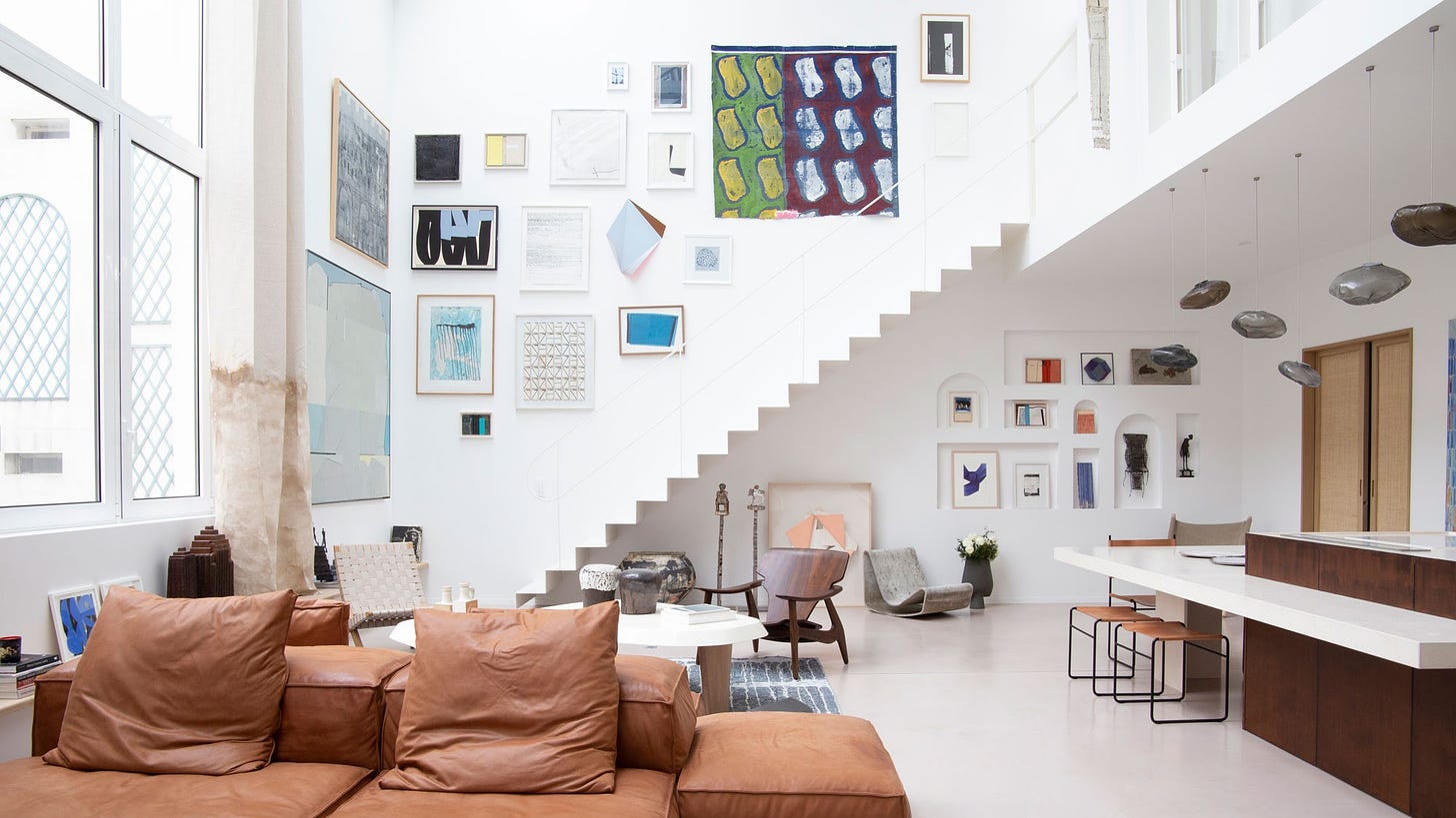 A living room with brown leather sofa and white staircase