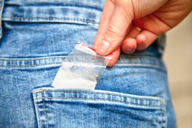 teenage schoolgirl reaching for cocaine in her back jeans pocket - drogue photos et images de collection