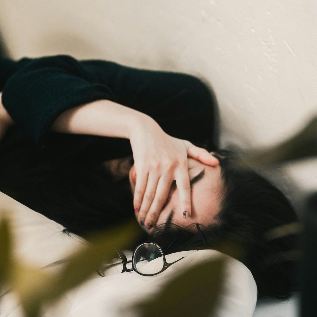 woman in black long sleeve shirt covering her face