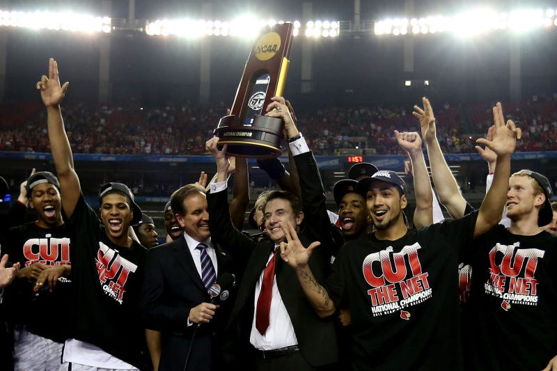 ATLANTA, GA - APRIL 08:  Head coach Rick Pitino of the Louisville Cardinals holds up the National Championship trophy as he celebrates with his players including Peyton Siva #3 (R of Pitino after they won 82-76 against the Michigan Wolverines during the 2013 NCAA Men's Final Four Championship at the Georgia Dome on April 8, 2013 in Atlanta, Georgia.  (Photo by Streeter Lecka/Getty Images)