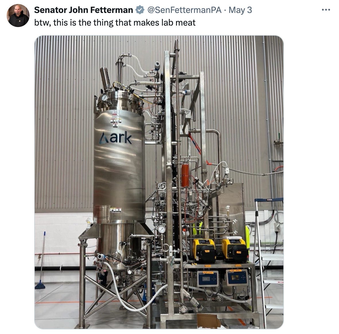 A screenshot of John Fetterman's tweet saying "btw, this is the thing that makes lab meat" with a photo of some metal machine.