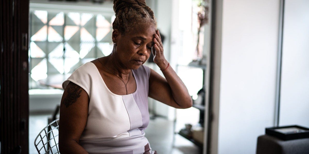 Mature woman with headache at home