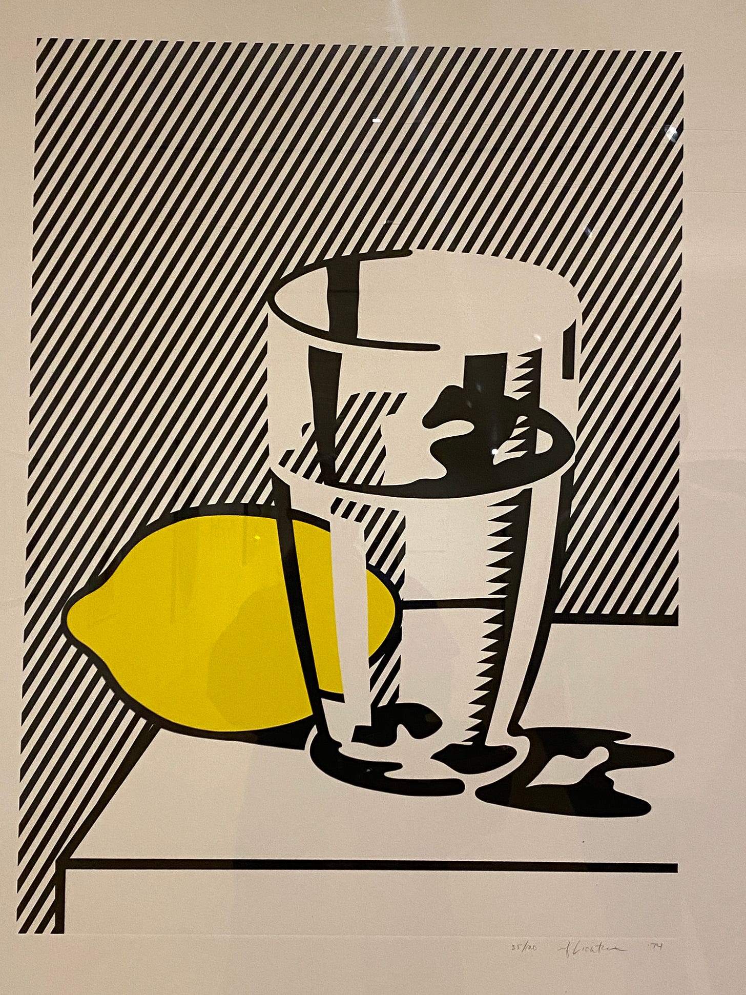 A graphical image with a class with liquid next to a yellow lemon with a black and white slanted line background.