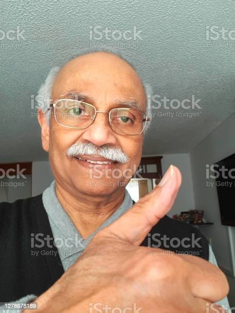 A 72 Year Old Smiling Asian Indian Man With A Huge Thumbs Up Cell Phone Self