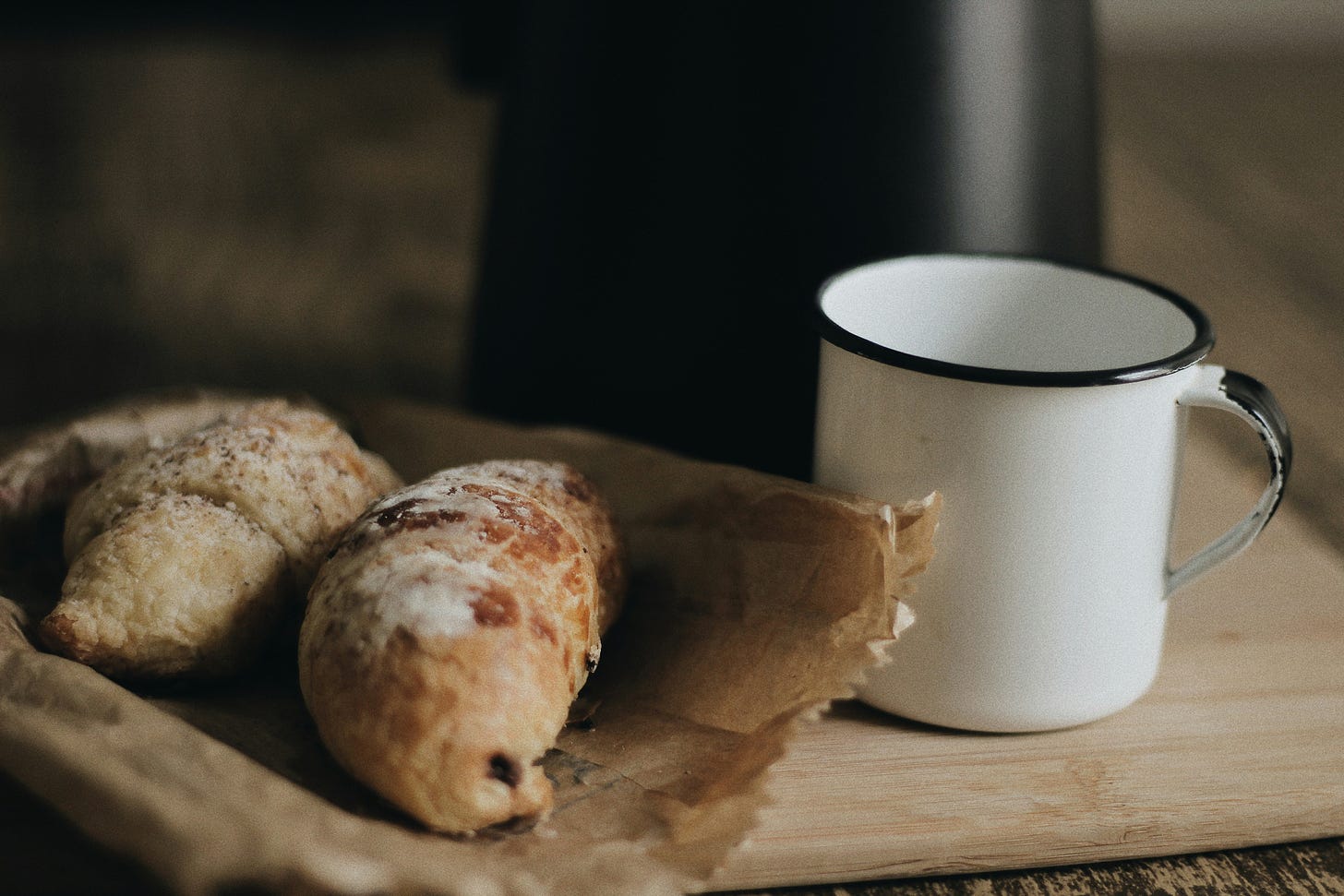 Image of bread and a white coffee mug on a table.