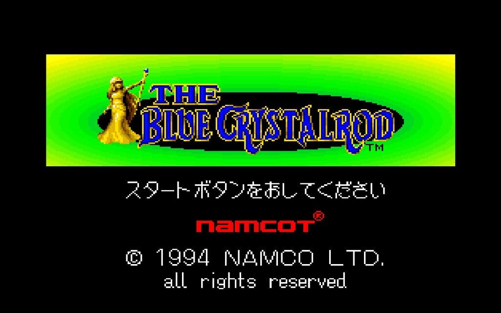 The title screen for The Blue Crystal Rod, featuring the game's title as a logo in English and in blue, with an image of Ishtar holding the titular Blue Crystal Rod to the left of it. Namcot and Namco credits are below. The background the logo is on top of is solid black.